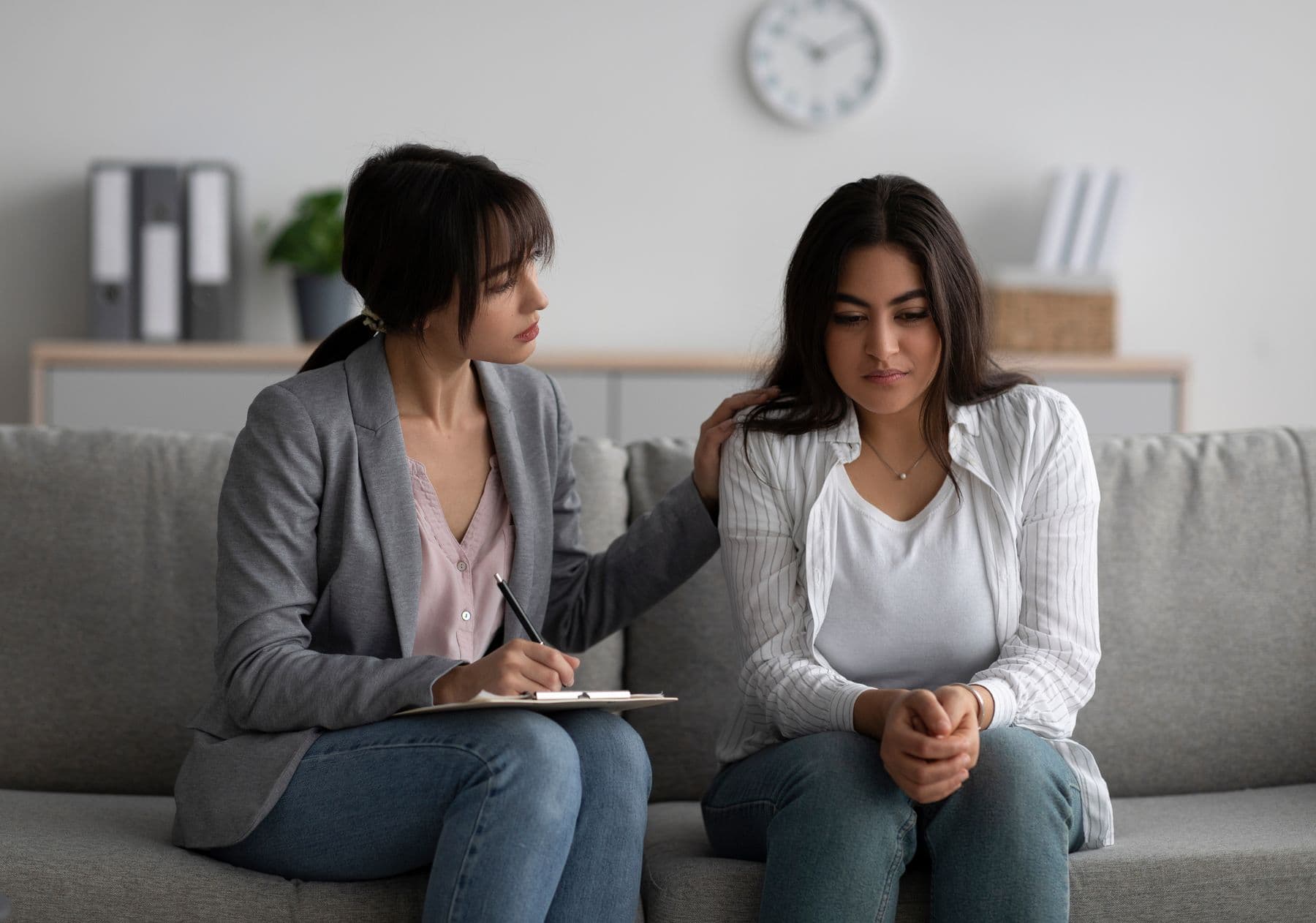 Two women talking on a sofa